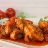 Sabroso pollo con tomate, cocinado a fuego lento hasta que esté tierno y jugoso, servido en una salsa roja vibrante.