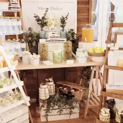 Mesa dulce con dulces, botellas de agua y un dispensador de jugo. Ideas para como hacer un candy bar.