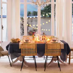 Elegante mesa puesta con velas y luces, perfecta para ideas para cumpleaños adultos en casa.