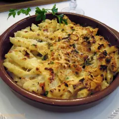 Macarrones con queso gratinados, burbujeantes y dorados, listos para servir. Un plato reconfortante y delicioso.