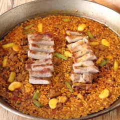 Paella de arroz con secreto ibérico, jugoso y lleno de sabor.