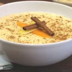 Delicioso arroz con leche Thermomix, espolvoreado con canela y decorado con piel de naranja y limón.