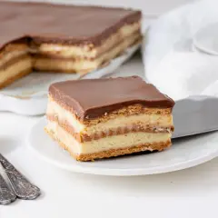 Una porción de tarta de la abuela, con capas de galleta y crema, cubierta de chocolate.