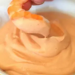 Camarón sumergiéndose en cremosa salsa rosa. ¡Un bocado perfecto!