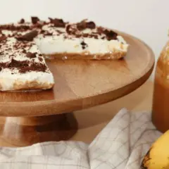 Deliciosa tarta banoffee con crema, plátano y virutas de chocolate, lista para disfrutar.