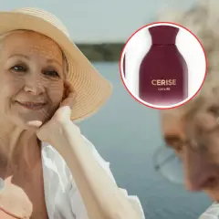 Mujer mayor sonriente con sombrero de paja y un frasco de perfume "CERISE".