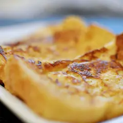 Tostadas francesas doradas y esponjosas en un plato blanco, listas para disfrutar.