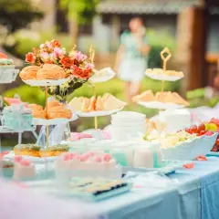 Deliciosa merienda baby shower con cupcakes, bollos, sándwiches y fruta fresca.