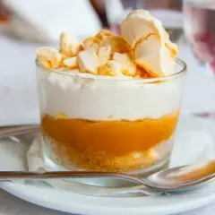 Delicioso postre en vaso con capas de galleta, dulce de leche y crema, coronado con merengue crocante. Un polvito uruguayo que invita a disfrutar.