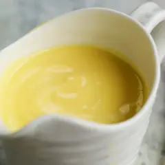 Crema amarilla y sedosa en una salsera blanca, lista para realzar cualquier plato. Es la clásica salsa holandesa.