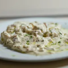 Deliciosa brandada de bacalao cremosa, con perejil picado y un toque de aceite de oliva. Un plato que invita a probar.