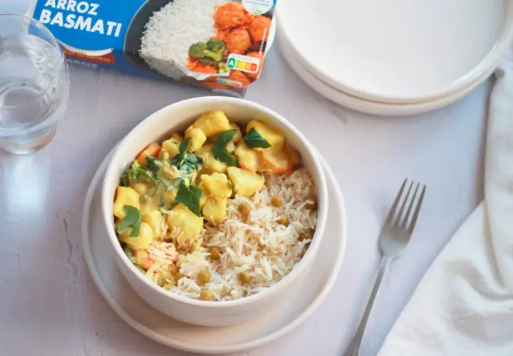 Un tazón de arroz basmati con guisantes y un curry cremoso de verduras, listo para disfrutar.