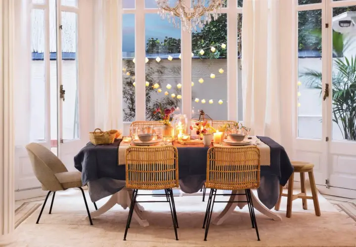 Elegante mesa puesta con velas y luces, perfecta para ideas para cumpleaños adultos en casa.