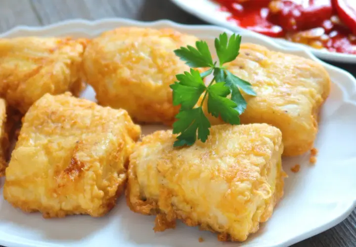 Crujientes trozos de merluza a la romana, dorados y listos para disfrutar. Un clásico delicioso.