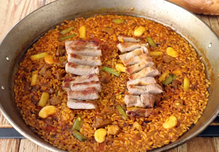 Paella de arroz con secreto ibérico, jugoso y lleno de sabor.