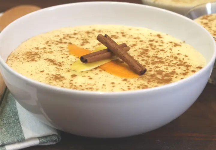 Delicioso arroz con leche Thermomix, espolvoreado con canela y decorado con piel de naranja y limón.