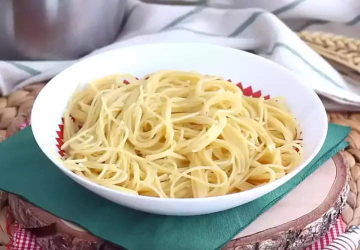 Un plato blanco lleno de espaguetis, perfecto para tus recetas de pasta favoritas.