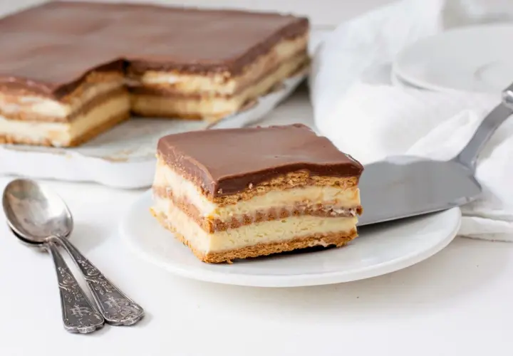 Una porción de tarta de la abuela, con capas de galleta y crema, cubierta de chocolate.