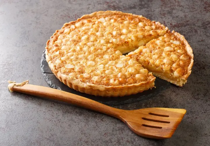 Tarta dorada con nueces sobre base de masa quebrada, lista para servir. Perfecta para tus recetas con masa quebrada.