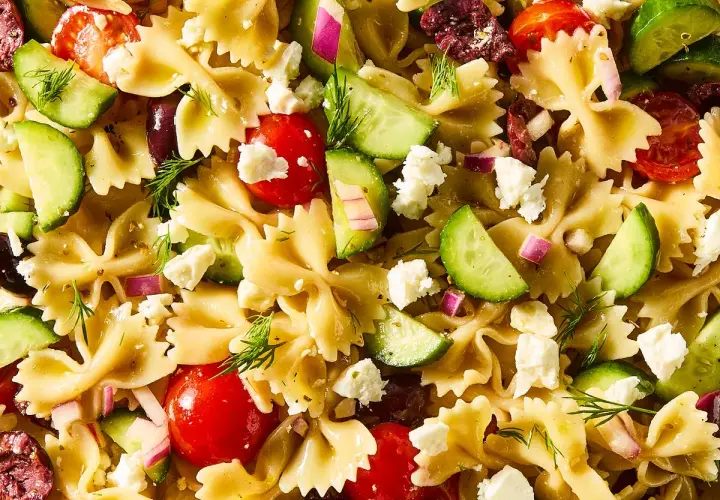 Ensalada de pasta con lazos, tomates cherry, pepino, queso feta, aceitunas y eneldo. ¡Una deliciosa pasta con verduras!