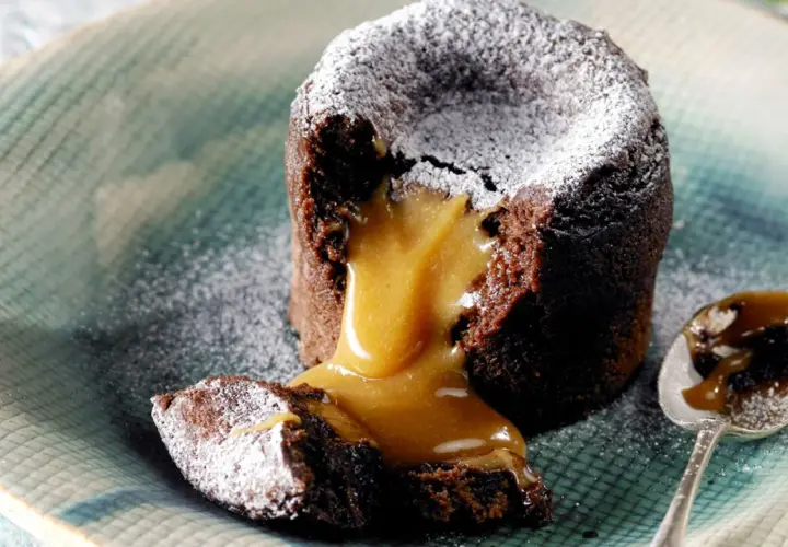 Coulant de chocolate con corazón líquido de caramelo, espolvoreado con azúcar glas. Un bocado irresistible.