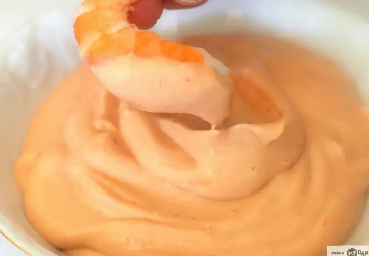 Camarón sumergiéndose en cremosa salsa rosa. ¡Un bocado perfecto!