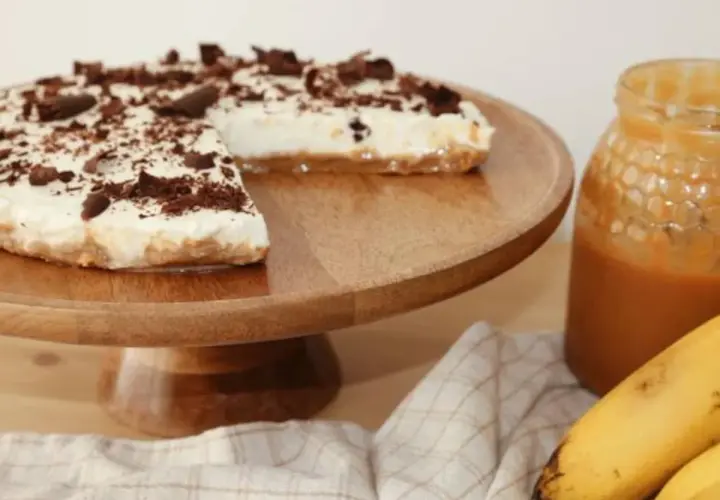 Deliciosa tarta banoffee con crema, plátano y virutas de chocolate, lista para disfrutar.