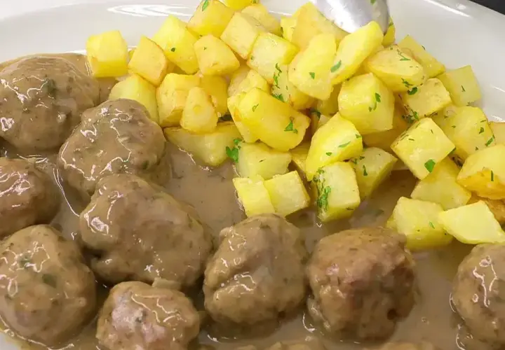 Deliciosas albóndigas en salsa con patatas fritas doradas. Una receta casera que te encantará.