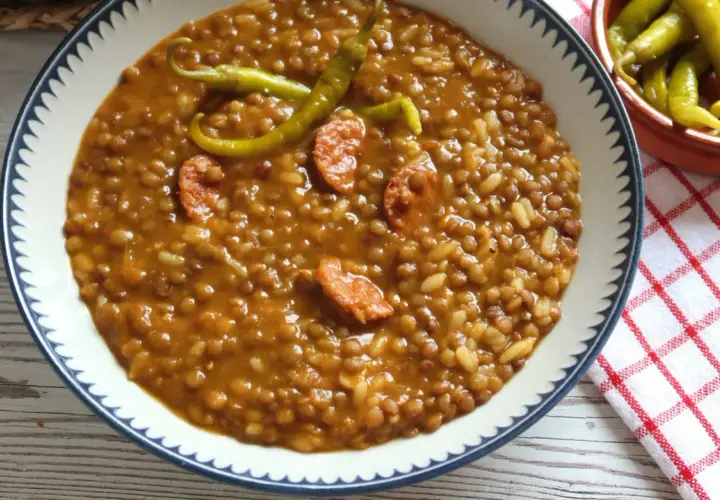Un plato de lentejas con arroz, trozos de chorizo y guindillas verdes. Un clásico reconfortante.