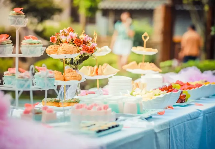 Deliciosa merienda baby shower con cupcakes, bollos, sándwiches y fruta fresca.