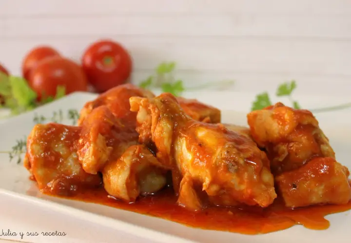 Sabroso pollo con tomate, cocinado a fuego lento hasta que esté tierno y jugoso, servido en una salsa roja vibrante.