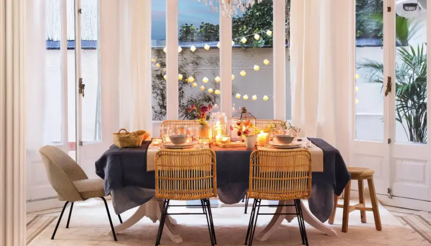 Elegante mesa puesta con velas y luces, perfecta para ideas para cumpleaños adultos en casa.