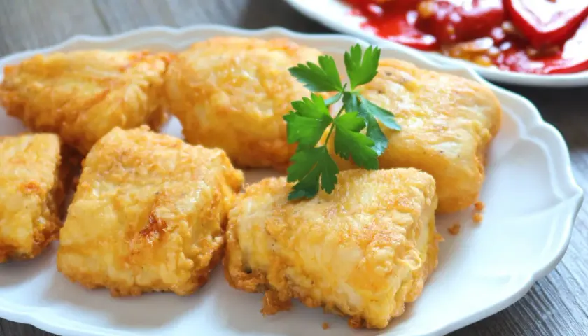 Crujientes trozos de merluza a la romana, dorados y listos para disfrutar. Un clásico delicioso.