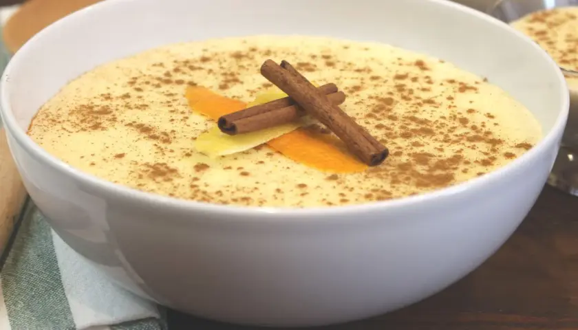 Delicioso arroz con leche Thermomix, espolvoreado con canela y decorado con piel de naranja y limón.