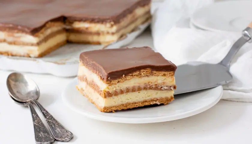 Una porción de tarta de la abuela, con capas de galleta y crema, cubierta de chocolate.