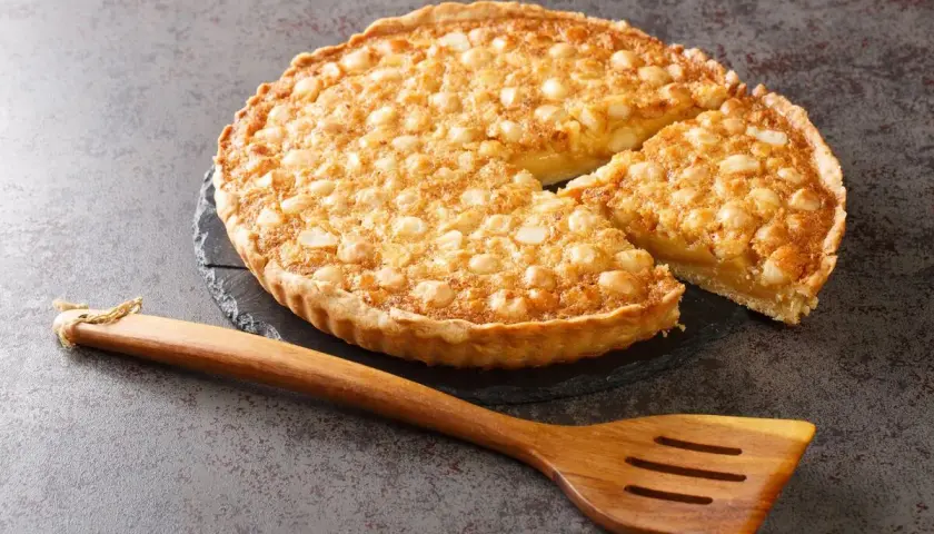 Tarta dorada con nueces sobre base de masa quebrada, lista para servir. Perfecta para tus recetas con masa quebrada.