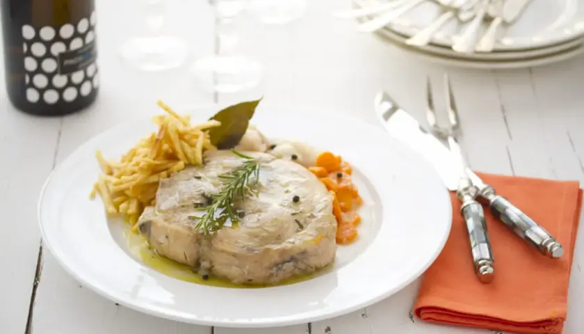 Bonito en escabeche con patatas paja y zanahorias. Un plato delicioso y bien presentado.