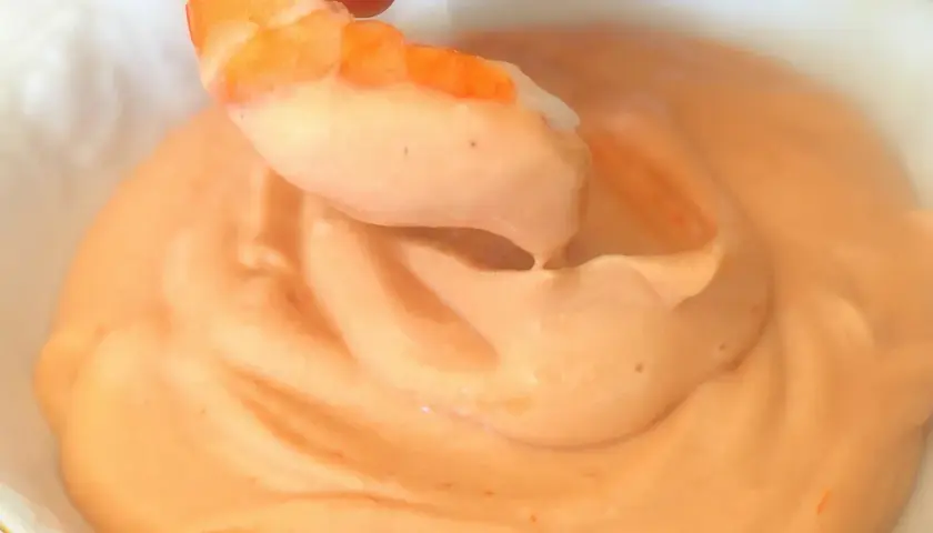 Camarón sumergiéndose en cremosa salsa rosa. ¡Un bocado perfecto!