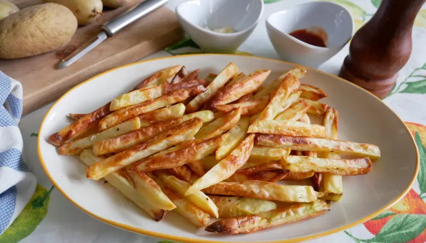 Patatas fritas crujientes hechas en airfryer, listas para disfrutar con salsas.