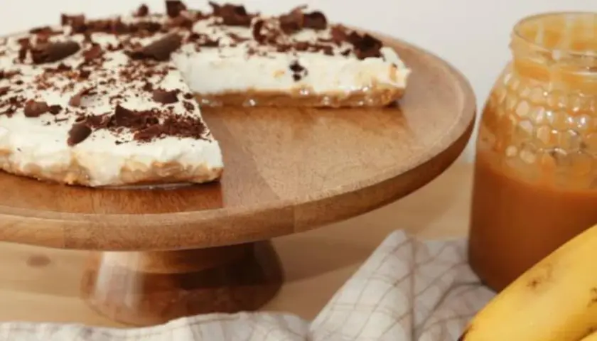 Deliciosa tarta banoffee con crema, plátano y virutas de chocolate, lista para disfrutar.