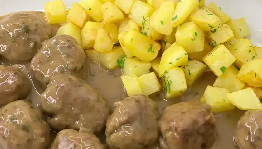 Deliciosas albóndigas en salsa con patatas fritas doradas. Una receta casera que te encantará.
