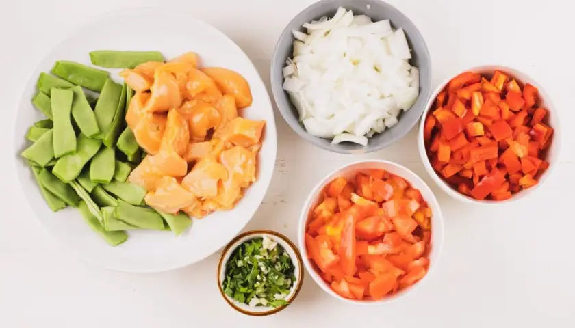 Ingredientes para fideuá de pollo: trozos de pollo, judías verdes, cebolla, pimiento rojo, tomate y perejil picado.