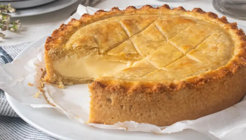 Un delicioso pastel vasco, con su masa dorada y relleno cremoso, listo para ser disfrutado.