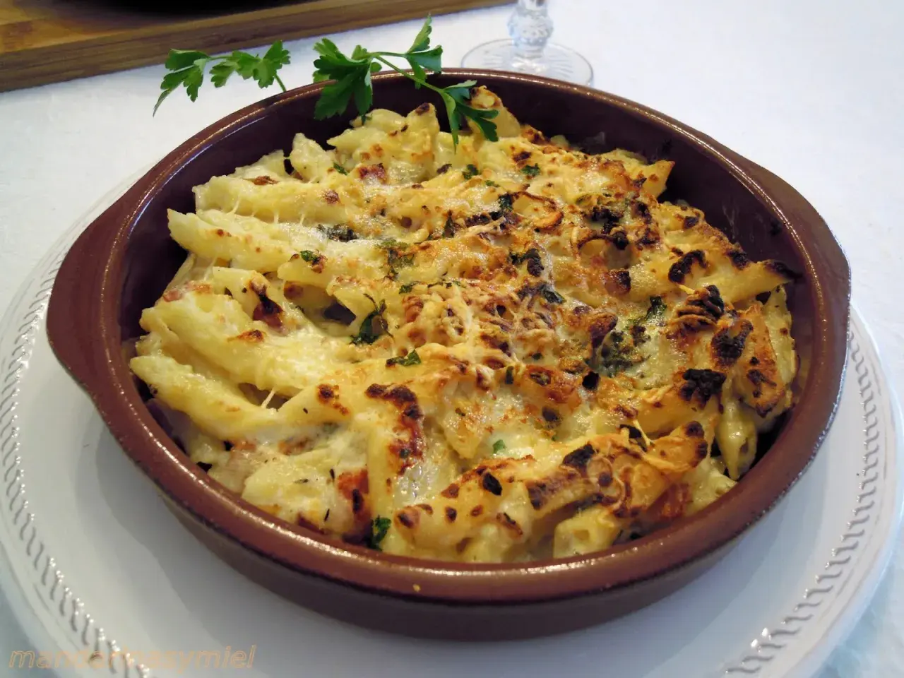 Macarrones con queso gratinados, burbujeantes y dorados, listos para servir. Un plato reconfortante y delicioso.