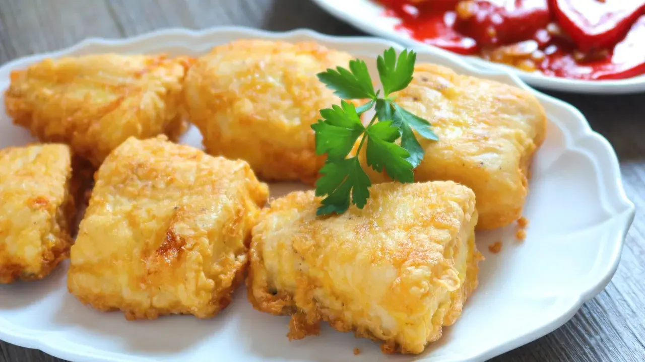 Crujientes trozos de merluza a la romana, dorados y listos para disfrutar. Un clásico delicioso.
