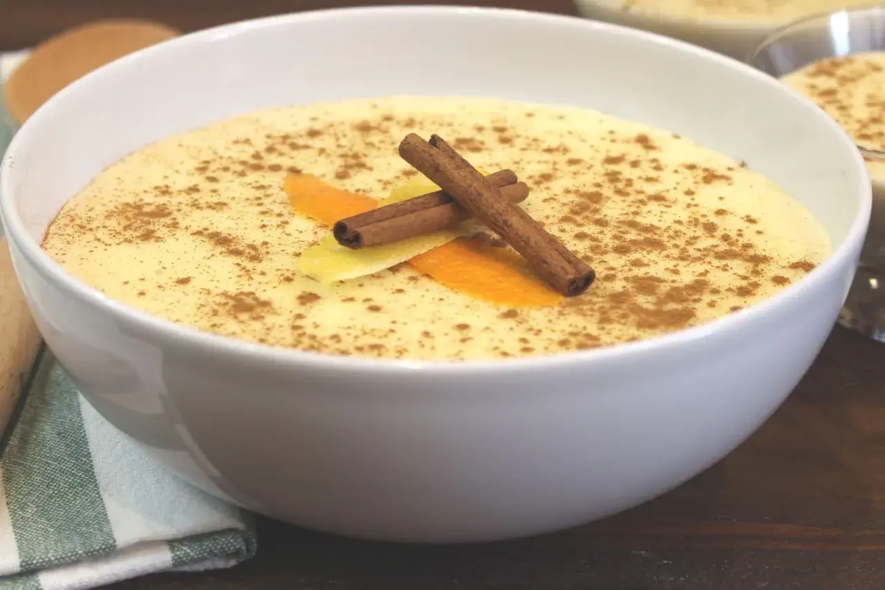Delicioso arroz con leche Thermomix, espolvoreado con canela y decorado con piel de naranja y limón.