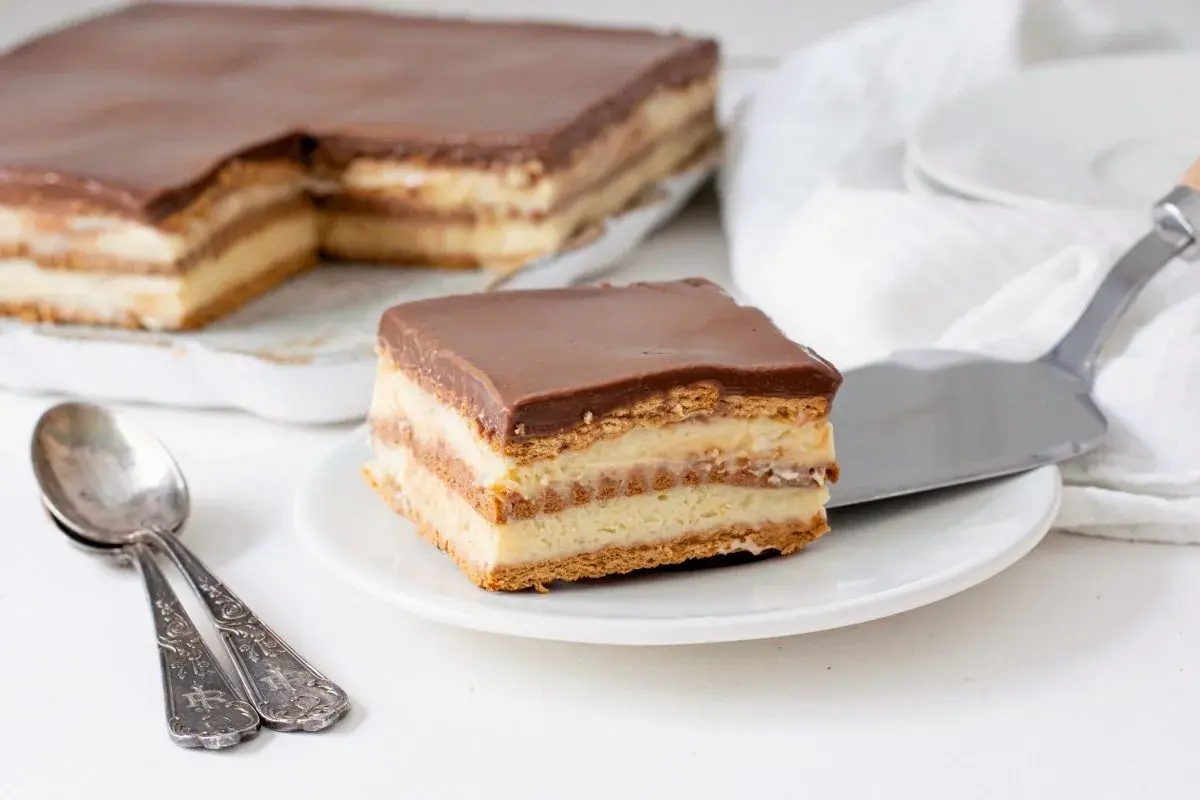Una porción de tarta de la abuela, con capas de galleta y crema, cubierta de chocolate.