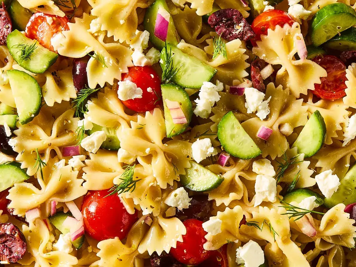 Ensalada de pasta con lazos, tomates cherry, pepino, queso feta, aceitunas y eneldo. ¡Una deliciosa pasta con verduras!