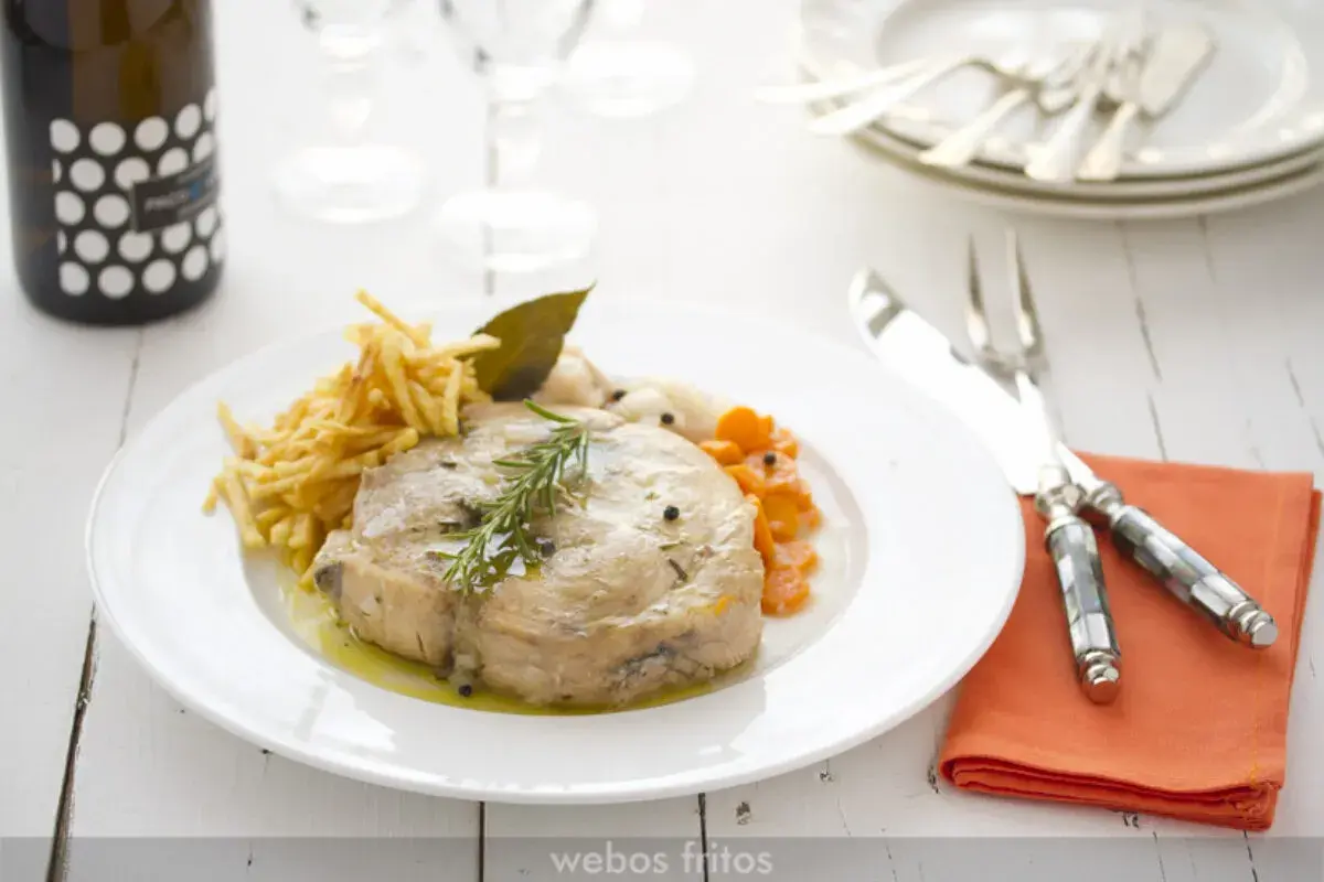Bonito en escabeche con patatas paja y zanahorias. Un plato delicioso y bien presentado.