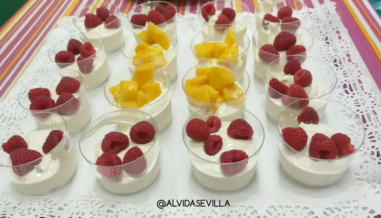 Postres individuales con crema y frambuesas o mango, perfectos para un cumpleaños saludable.